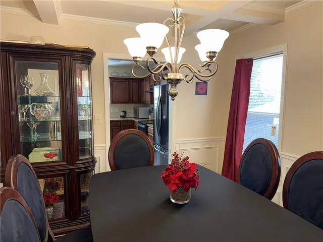 a front view of a dining room with furniture and chandelier