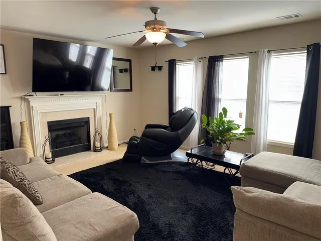 a living room with furniture a flat screen tv and a fireplace