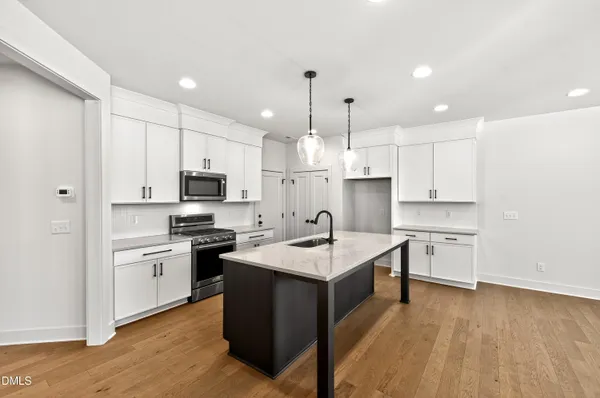 a kitchen with white cabinets appliances and sink