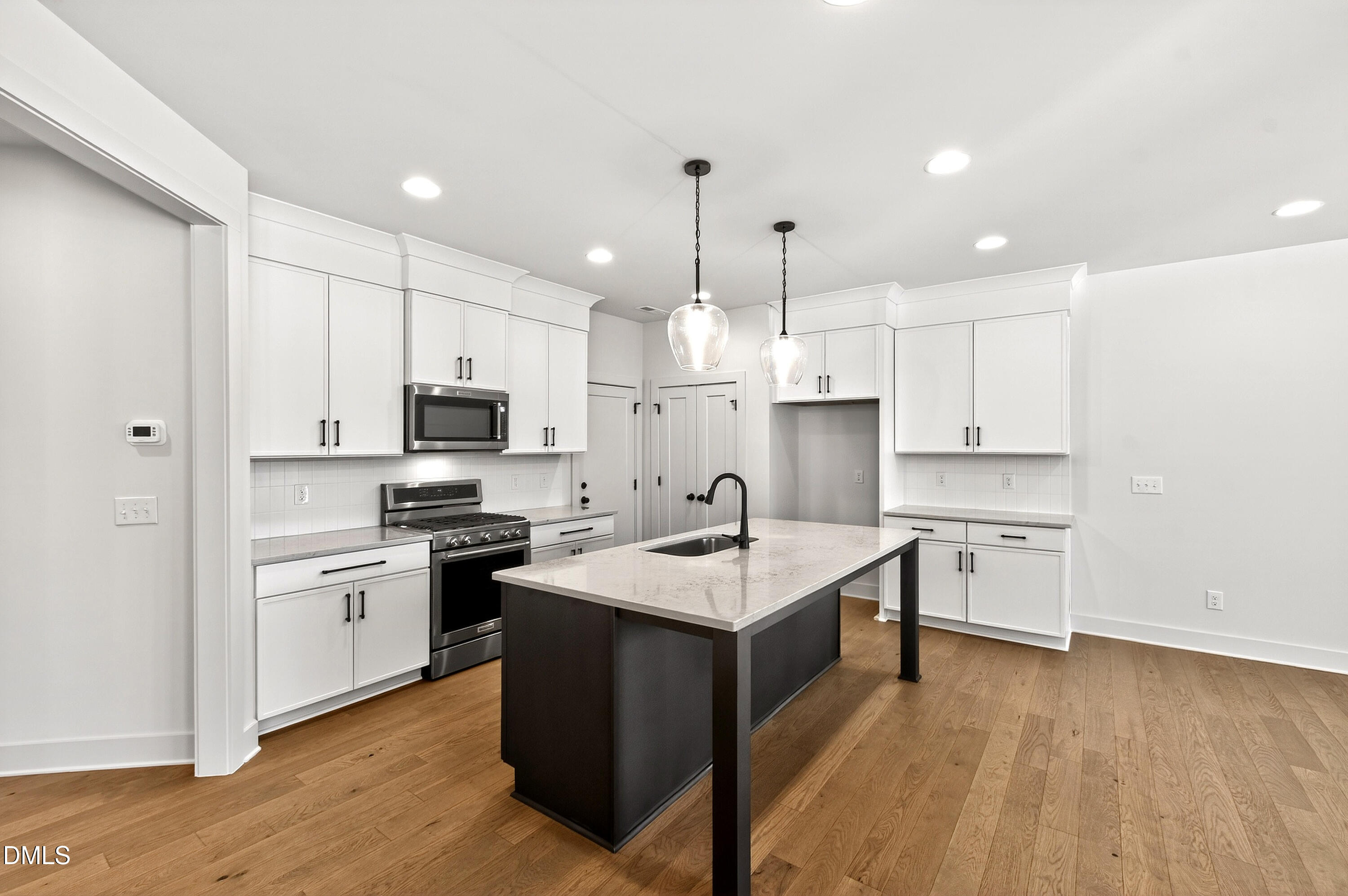 a kitchen with white cabinets appliances and sink