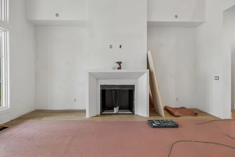 a view of an empty room with a fireplace and a window