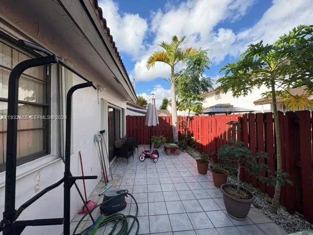 a view of a backyard with potted plants and wooden fence