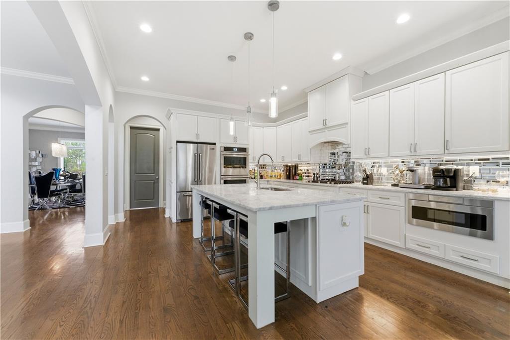 1616 Palmilla Way Southwest Stockbridge, GA 30281 - Photo 15 of 50 a kitchen with wooden floor and white stainless steel appliances