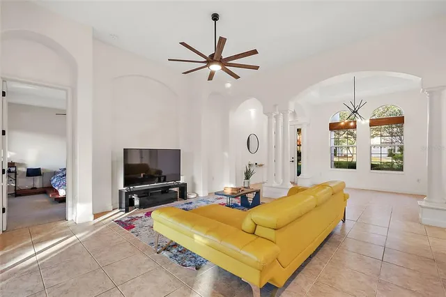 a living room with furniture flat screen tv and a chandelier