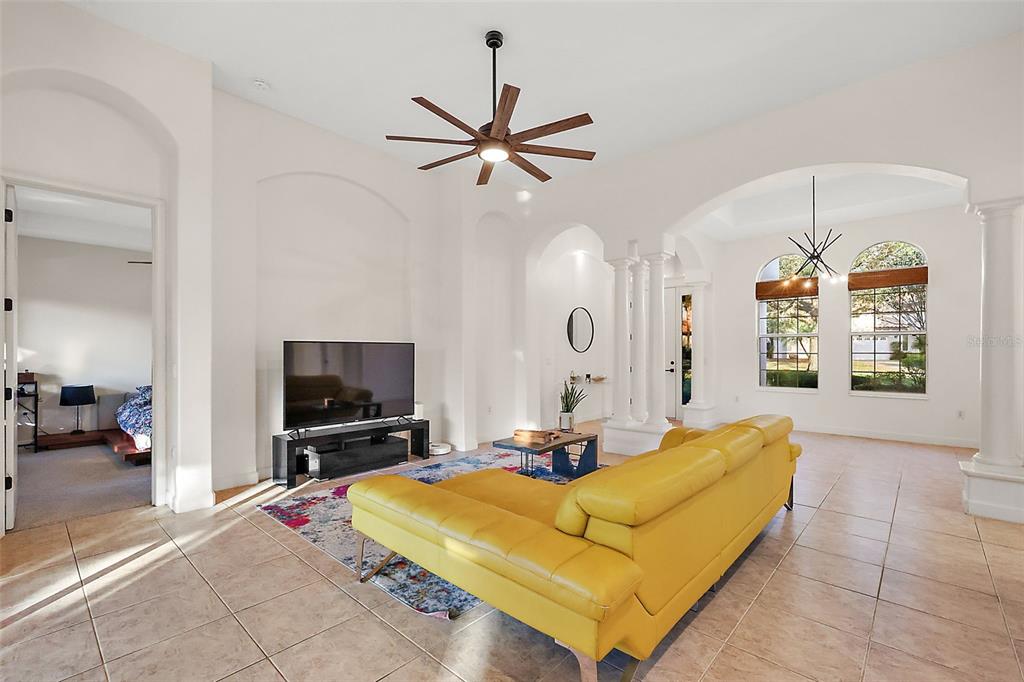 9930 Santa Barbara Court Howey-in-the-Hills, FL 34737 - Photo 15 of 44 a living room with furniture flat screen tv and a chandelier