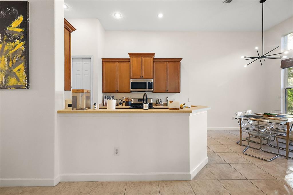 9930 Santa Barbara Court Howey-in-the-Hills, FL 34737 - Photo 17 of 44 a room with stainless steel appliances kitchen island granite countertop a refrigerator a stove a sink with a dining table and chair with wooden floor