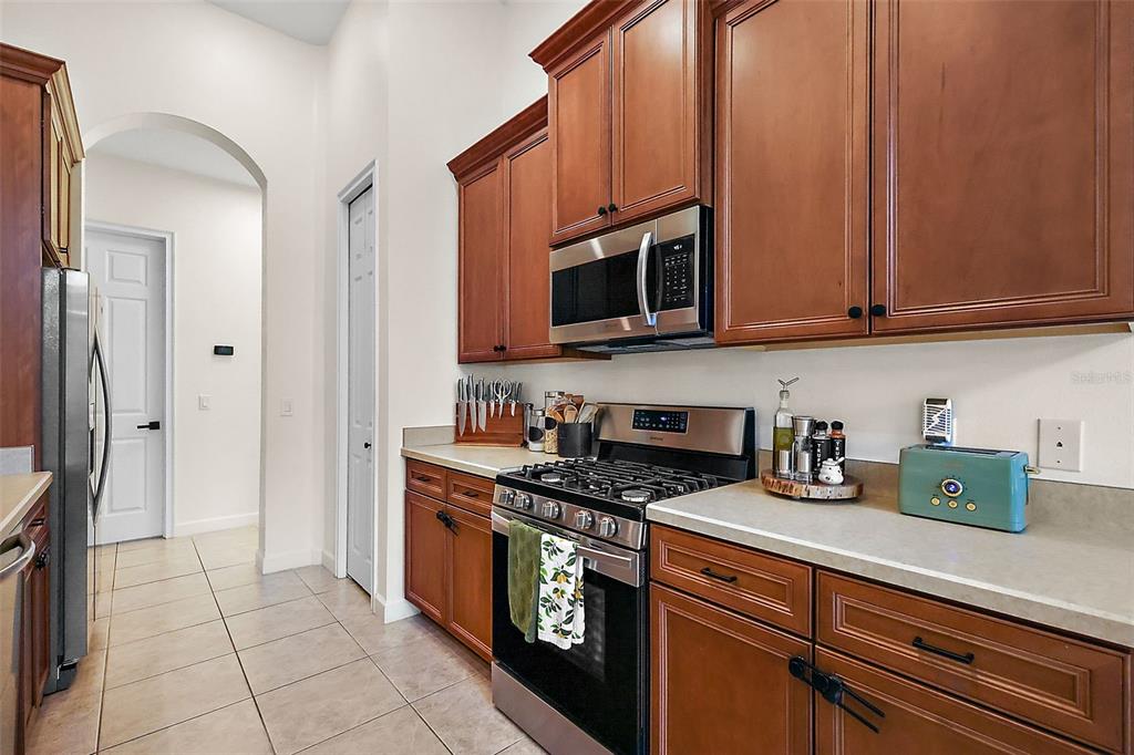 9930 Santa Barbara Court Howey-in-the-Hills, FL 34737 - Photo 20 of 44 a kitchen with stainless steel appliances granite countertop a stove a sink and a microwave