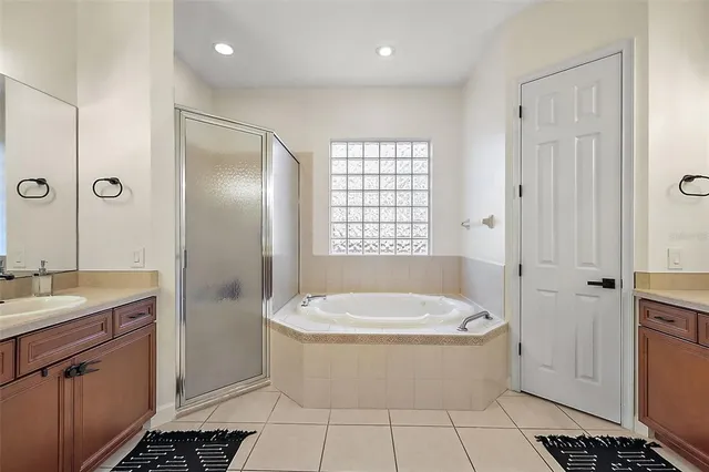 a bathroom with a tub a sink a window and a shower
