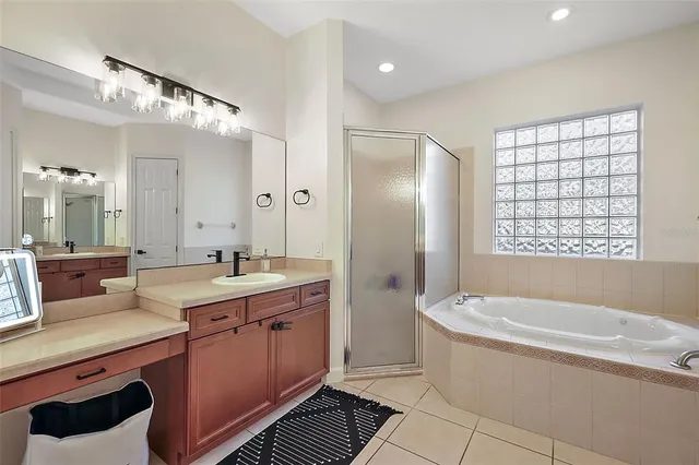 a spacious bathroom with a tub sink shower and mirror