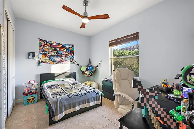 a bedroom with a bed a couch and a potted plant