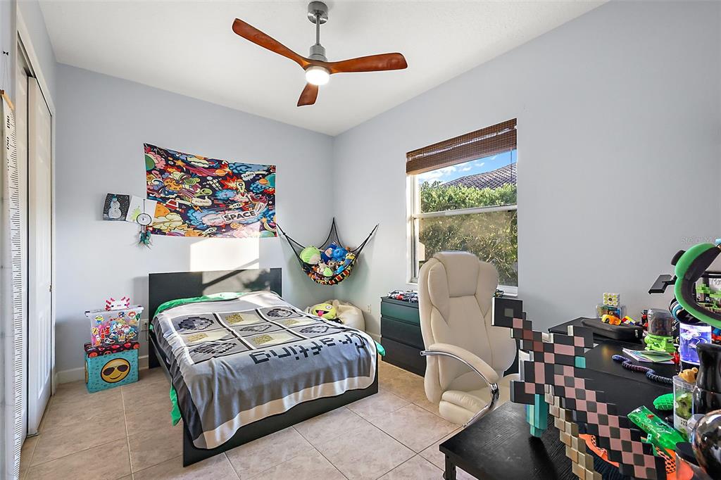 9930 Santa Barbara Court Howey-in-the-Hills, FL 34737 - Photo 29 of 44 a bedroom with a bed a couch and a potted plant