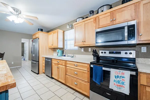 a kitchen with stainless steel appliances granite countertop a stove a sink and a microwave