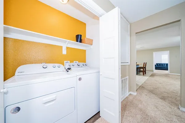 a view of washer and dryer with kitchen in the background