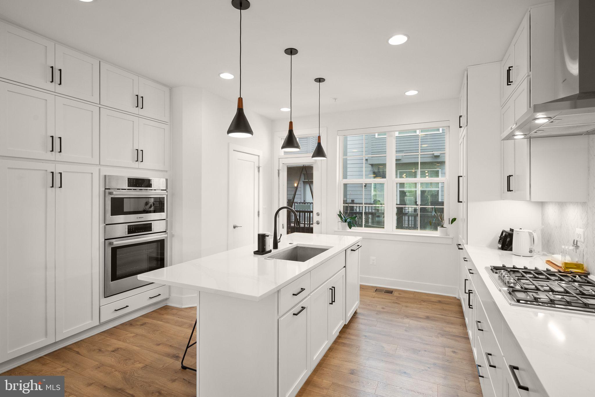 11258 Faraday Park Drive Reston, VA 20190 - Photo 11 of 44 a large white kitchen with stainless steel appliances granite countertop a stove a sink and a refrigerator