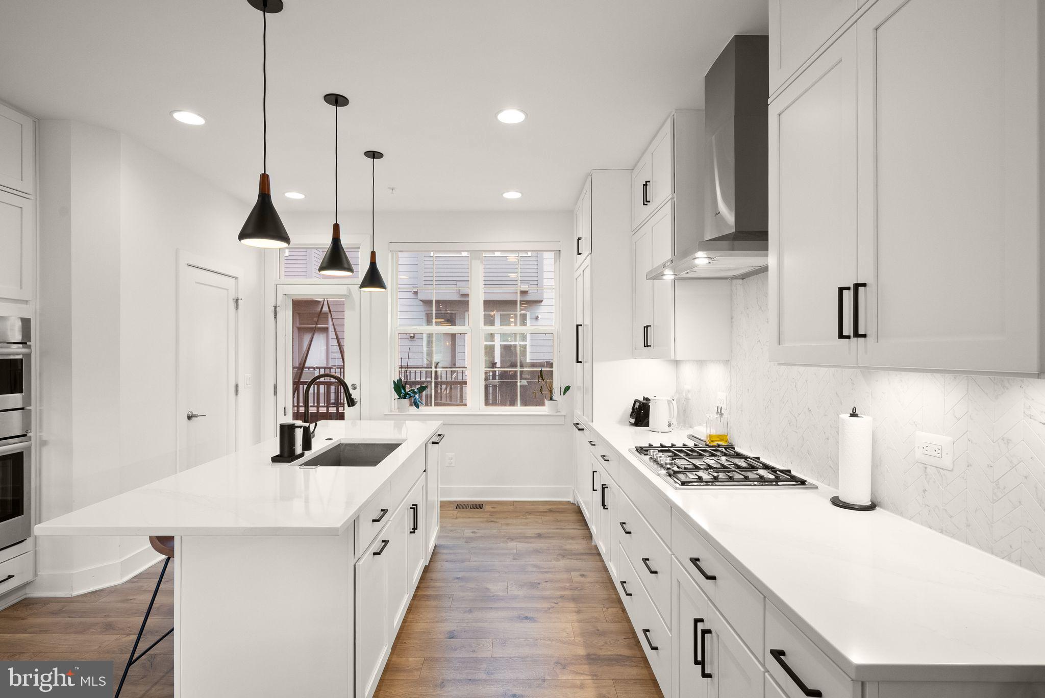 11258 Faraday Park Drive Reston, VA 20190 - Photo 12 of 44 a kitchen with stainless steel appliances kitchen island granite countertop a sink a counter top space and cabinets