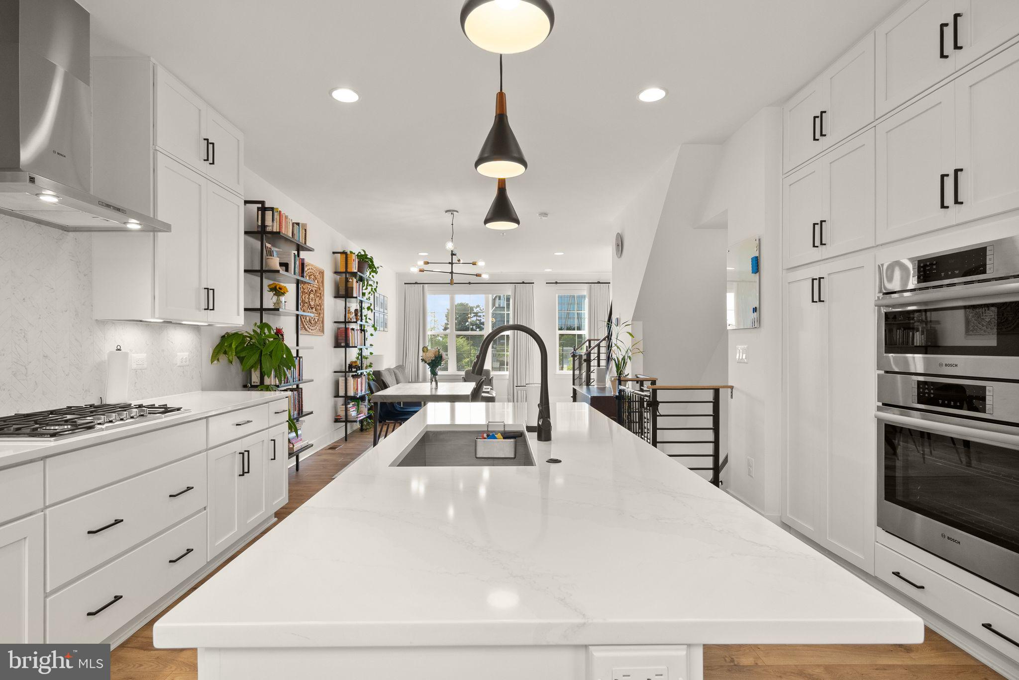 11258 Faraday Park Drive Reston, VA 20190 - Photo 15 of 44 a kitchen with stainless steel appliances kitchen island granite countertop a stove a sink a refrigerator and a white cabinets