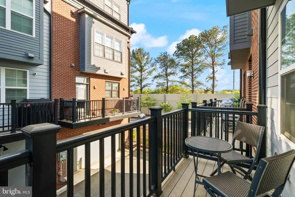 a view of a balcony with wooden chairs and floor and wooden fence