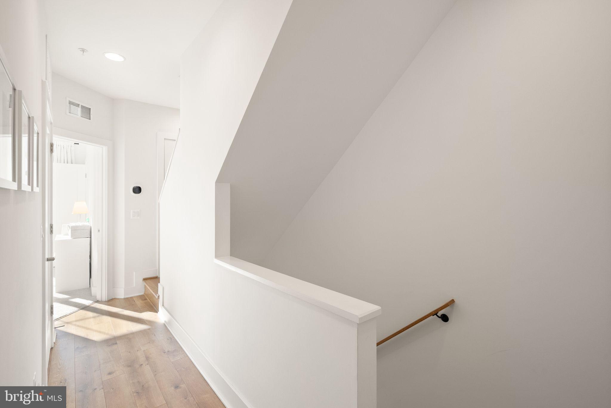 11258 Faraday Park Drive Reston, VA 20190 - Photo 20 of 44 a view of a hallway with wooden floor and a bathroom