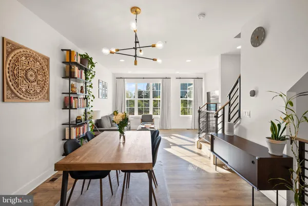 a view of a livingroom and dining room with furniture wooden floor and a chandelier