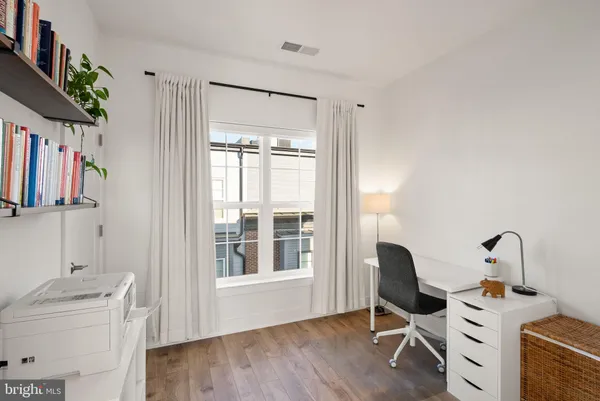 a view of workspace with wooden floor windows cabinet and glass door