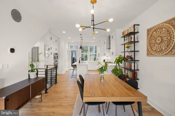 a dining room with stainless steel appliances kitchen island granite countertop furniture wooden floor and window