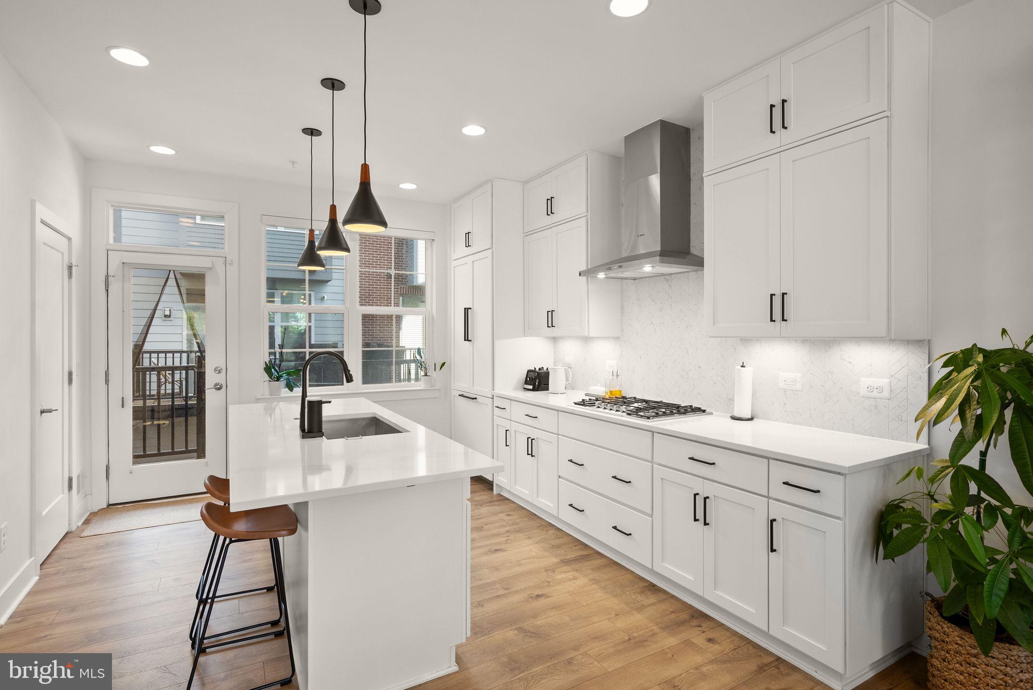 11258 Faraday Park Drive Reston, VA 20190 - Photo 10 of 44 a kitchen with stainless steel appliances kitchen island granite countertop a sink a stove and a refrigerator