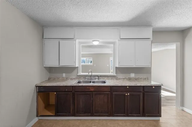 a kitchen with granite countertop a sink cabinets and stainless steel appliances