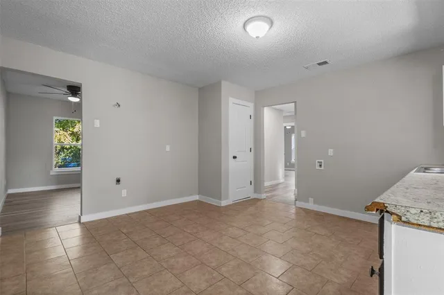 an empty room with kitchen space and entrance door