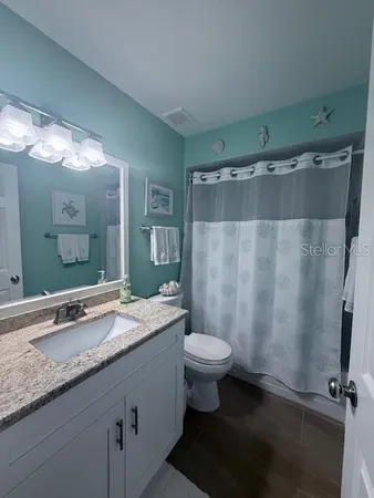a bathroom with a granite countertop sink toilet and shower