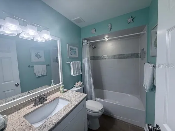 a bathroom with a granite countertop sink mirror toilet and bathtub