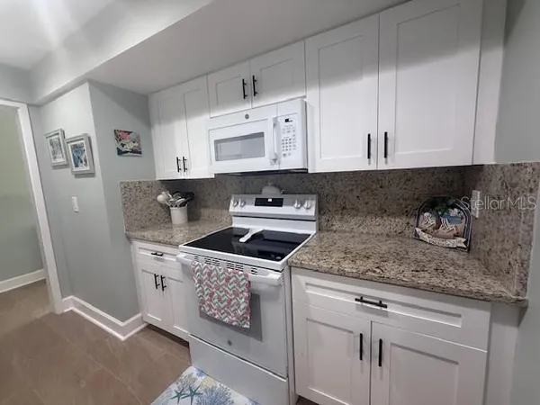 a kitchen with stainless steel appliances granite countertop a sink stove and cabinets