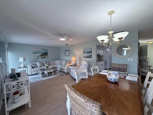 a living room with furniture chandelier and a mirror