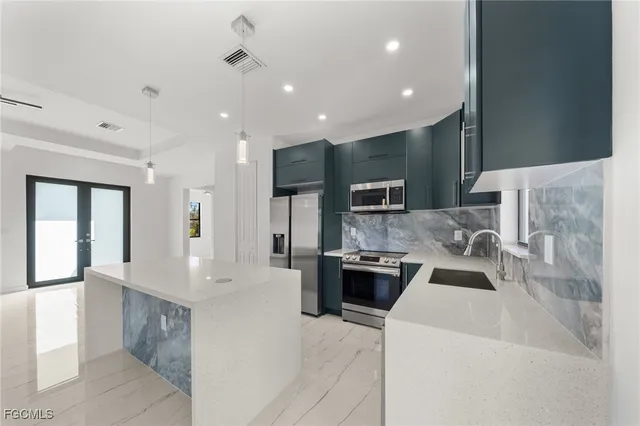 a kitchen with stainless steel appliances granite countertop a refrigerator and a stove top oven