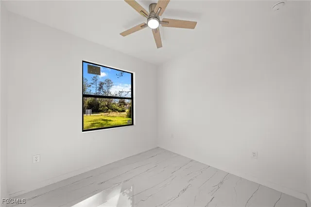 an empty room with closet and a ceiling fan