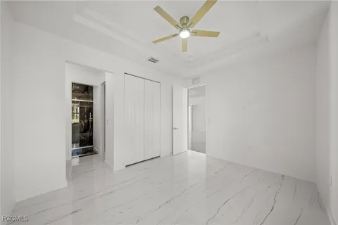 an empty room with windows and fan