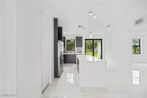 a large kitchen with kitchen island a sink stainless steel appliances and cabinets