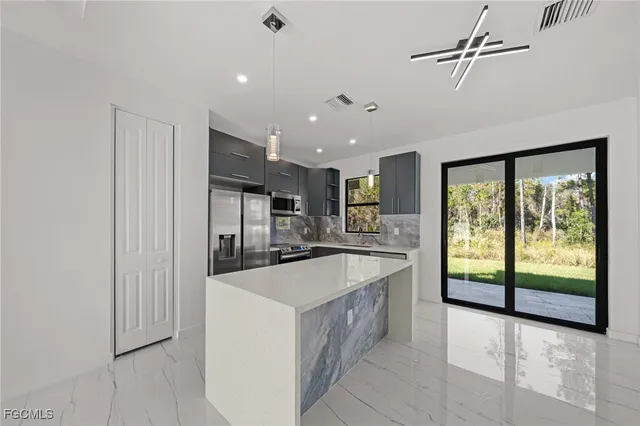 a large kitchen with kitchen island a sink stainless steel appliances and cabinets