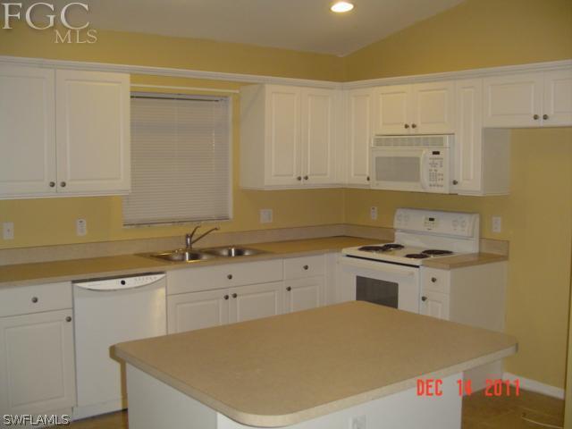18425 Lee Road Fort Myers, FL 33967 - Photo 4 of 9 a kitchen with granite countertop a sink a stove and cabinets
