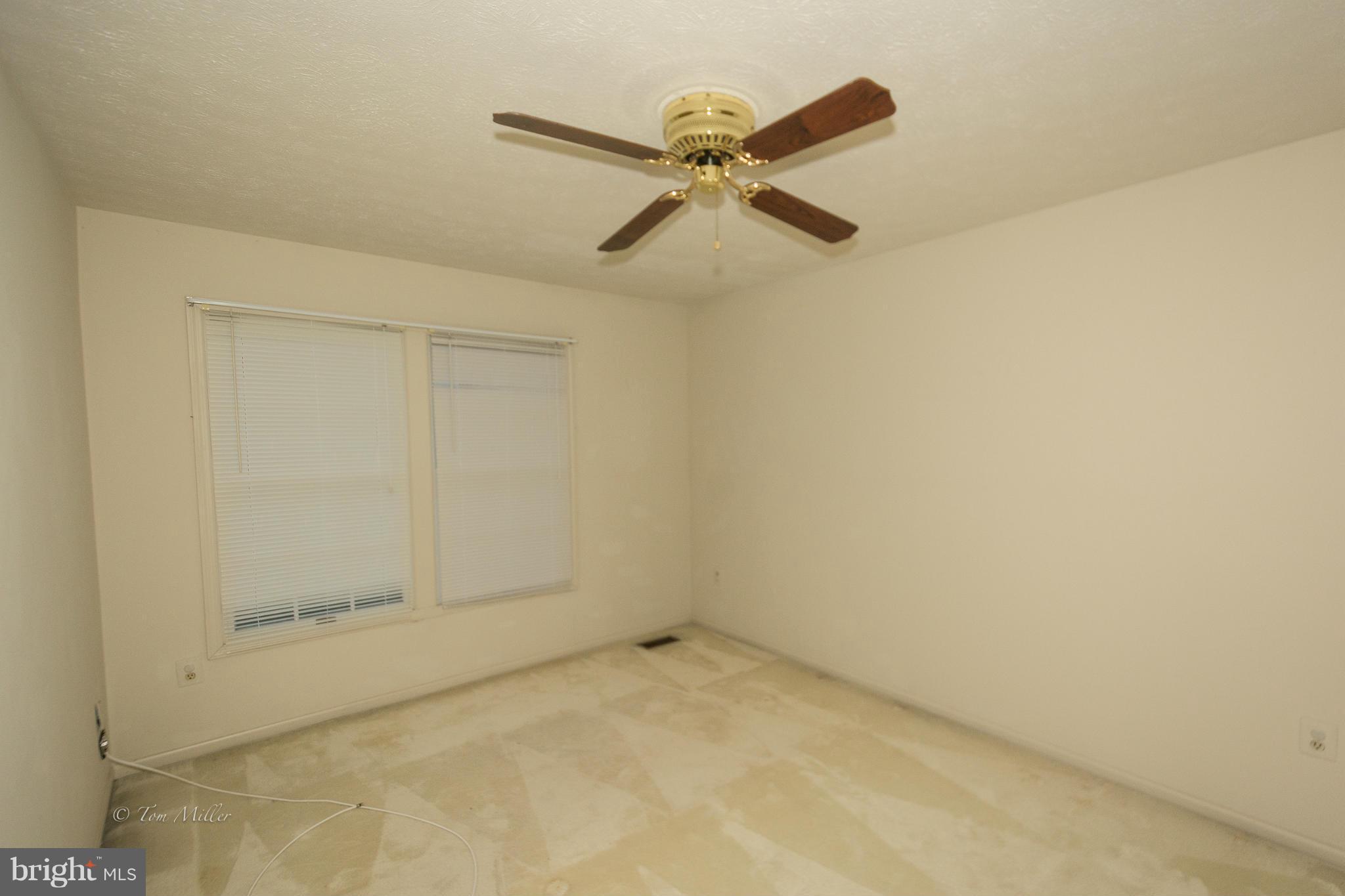 910 Metfield Road Baltimore, MD 21286 - Photo 19 of 22 an empty room with a ceiling fan and carpet