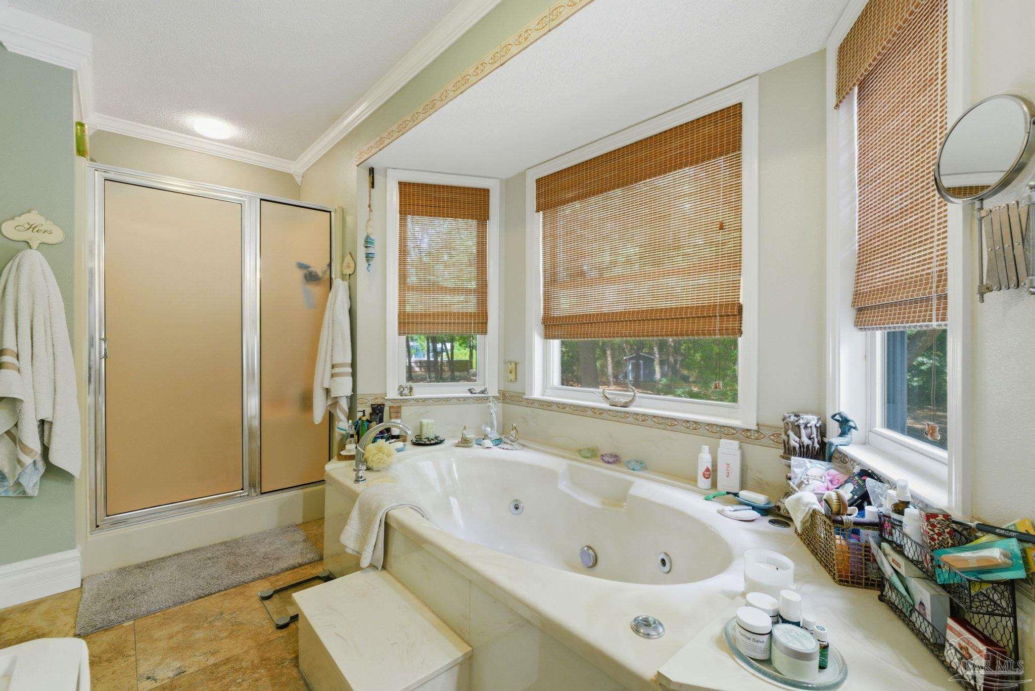 6930 Summit Way Milton, FL 32570 - Photo 30 of 71 a bathroom with a tub a sink and a large mirror next to a window