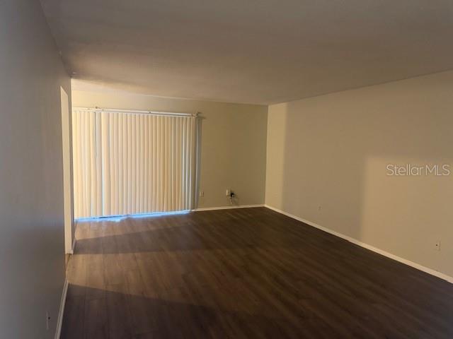 7309 Abonado Road, Unit 7309 Tampa, FL 33615 - Photo 3 of 17 an empty room with wooden floor and windows with curtains