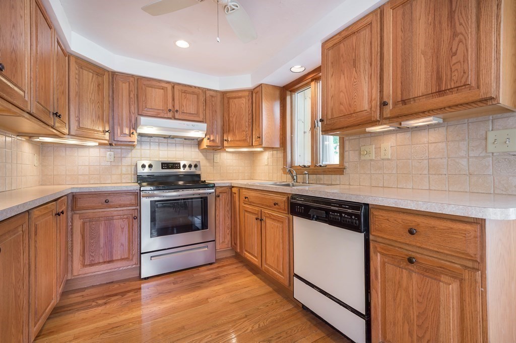 5 Rich Road Woburn, MA 01801 - Photo 5 of 25 a kitchen with granite countertop wooden cabinets and stainless steel appliances