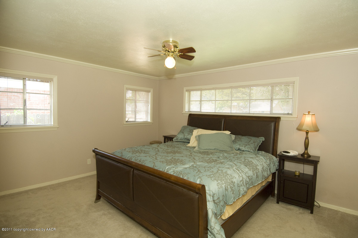1221 South Austin Street Amarillo, TX 79102 - Photo 17 of 28 a bedroom with a bed and a chandelier