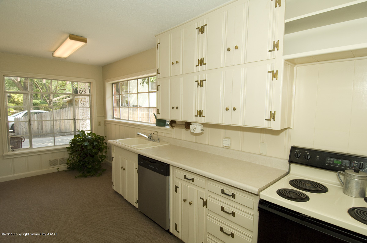 1221 South Austin Street Amarillo, TX 79102 - Photo 5 of 28 a kitchen with a sink stove and cabinets