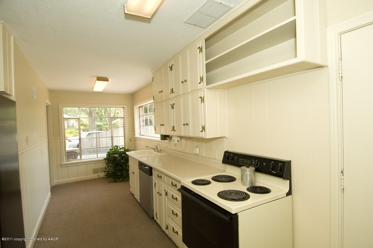1221 South Austin Street Amarillo, TX 79102 - Photo 9 of 28 a kitchen that has a sink and a stove in it