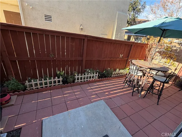 a view of a chairs and table in the back yard of the house