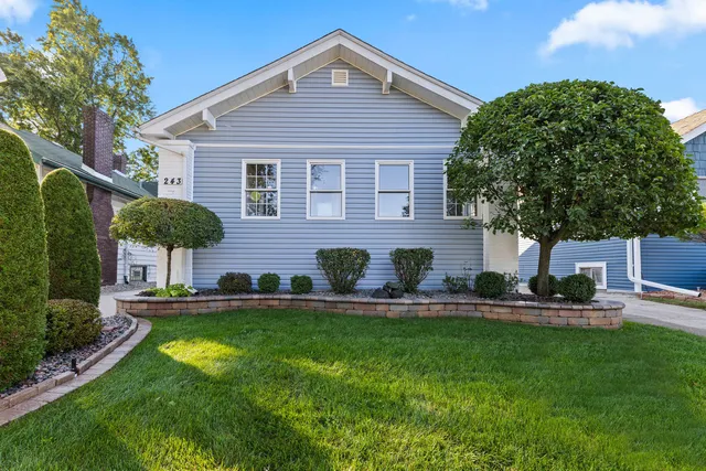a front view of a house with a garden and plants