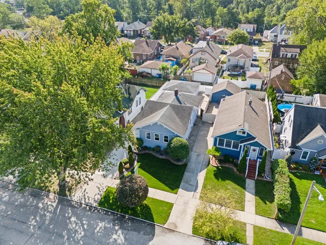 an aerial view of a residential houses with yard