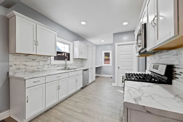a kitchen with granite countertop a sink stove and cabinets