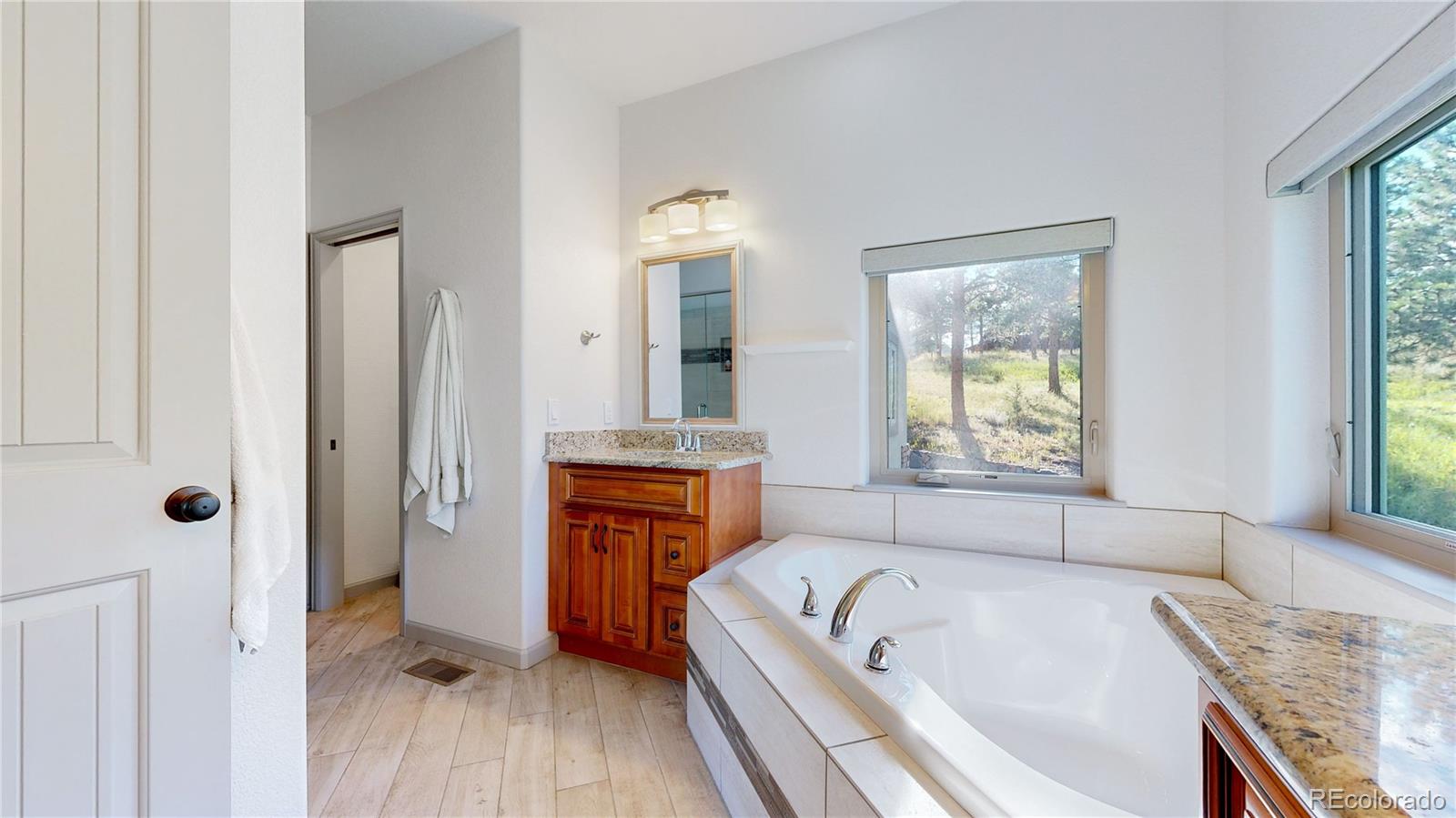 230 Mohawk Trail Pine, CO 80470 - Photo 15 of 39 a bathroom with a granite countertop tub sink a window and shower
